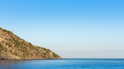 Quiet serene blue sea and wooded mountainside, Vesele bay in the Sudak Municipality of the Crimea