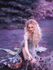 cute girl in old gray dress with long cut train and open legs sitting on knees and gathering wild...