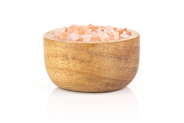 Fototapeta na wymiar Lot of pieces of pink himalayan salt crystals in a wooden bowl isolated on white background