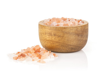 Fototapeta na wymiar Lot of pieces of mineral pink himalayan salt crystals in a wooden bowl isolated on white background