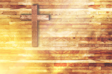wood cross on wooden background in church with ray of light from below