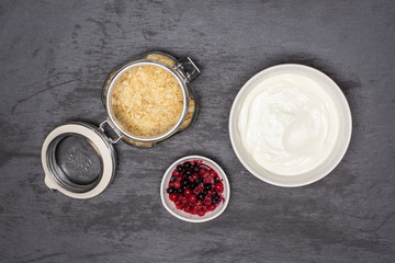 Prepare shortbread crumbs, cottage cream and berries. recipe step by step no bake cheesecake flatlay on grey stone