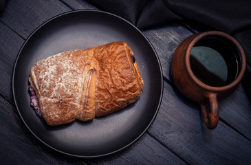 Coffee and cake with filling on dark background