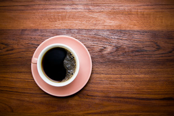 Hot coffee of cup trendy color of the year 2019 living coral. On wooden background