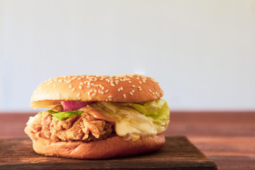 Homemade chicken burger on wooden table. tasty with lettuce, tomato, cheese,  sauce Copy space for your text