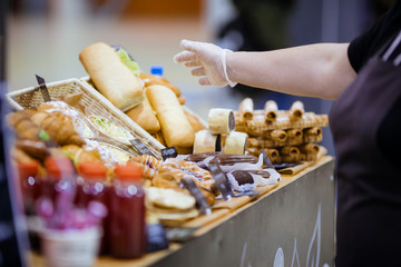 Hand sellers takes bread from the counter in the store