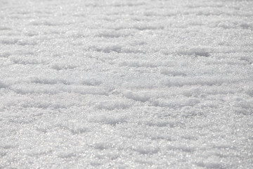 Wavy texture of snow with ice crystals on the surface. Beautiful bokeh