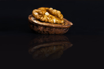 Halbe Walnuss auf spiegelnder Oberfläche