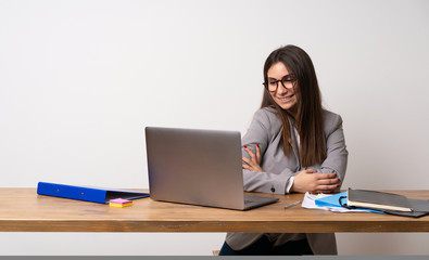 Business woman in a office with glasses and smiling