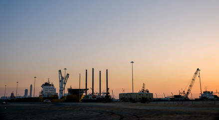Fototapeta na wymiar Evening view of Zayed Port with docked ships and oil rigs