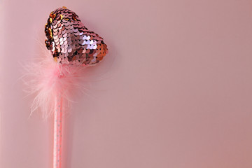 Fairy magic wand on a pink pastel background.