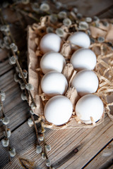 Willow bouquet and easter eggs on wooden table.