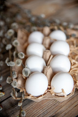 Willow bouquet and easter eggs on wooden table.