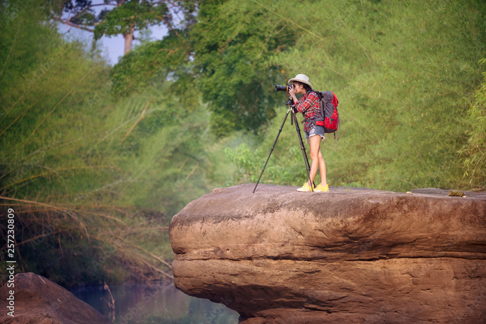 Wall mural Backpack woman take photo with nature background