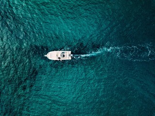 Aerial view of speed boat in motion in blue sea in Italy.