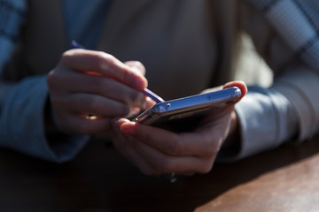 the man or woman hold the smart phone in the hand.