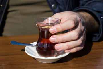 the man hold glass of tea in the hand.