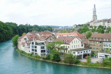 Fototapeta na wymiar A cityscape view old town of Bern, the capital of Switzerland in overcast day. The city is crowded with houses and buildings, mountain, bridge and river background