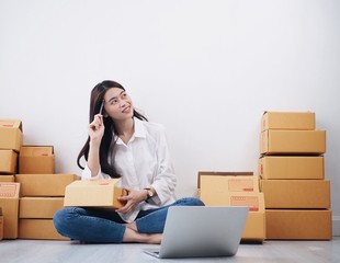 Asian woman working at home with her laptop,she’s online seller.