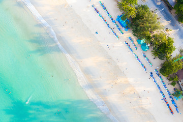 Fototapeta na wymiar Aerial view of sandy beach with tourists swimming in beautiful clear sea water in Phuket, Thailand.