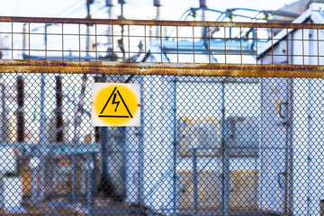 A sign warning of the dangers of high electrical voltage hangs on the mesh fence that surrounds the...