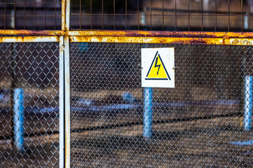 A sign warning of the dangers of high electrical voltage hangs on the mesh fence that surrounds the...