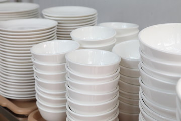White set of ceramic plate, dish, cup stacking up the rack for kitchen and restaurant organizing design 