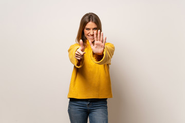 Woman with yellow sweater over isolated wall counting six with fingers