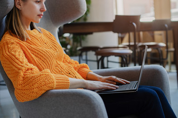 Young female manager using laptop while sitting at co-working, Business woman working on laptop in...