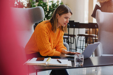 Happy successful businesswoman working on laptop in co-working place, smiling female entrepreneur...