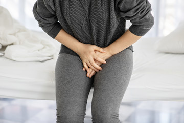 woman have bladder pain sitting on bed in bedroom after wake up,Healthcare concept