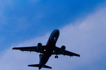 Fototapeta na wymiar Silhouette airplane flying taking off on blue sky with twilight sunset