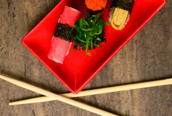 Chopsticks near sushi with fish and seaweed