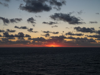 Fototapeta na wymiar Beautiful orange sky when sunset over the mountain with ocean foreground