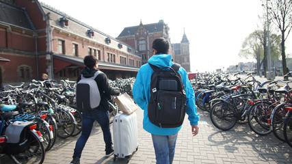 Bicycles parking in front of Amsterdam main station with tourist walking