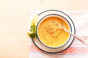 Traditional lentil soup in a white plate on a wooden table