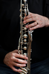 Fototapeta premium The hands of a musician playing the bass clarinet