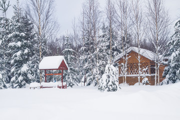 Wooden gazebo at a private house in the winter near the forest
