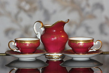 Coffee set of red porcelain with a blurred background.