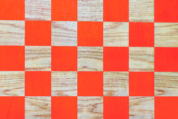 Wooden chessboard with orange cells. Checkerboard background.