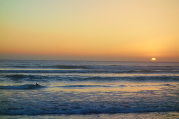 Sunset in Taghazout with a surfer in the background, Morocco