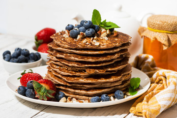 stack of homemade delicious pancakes for breakfast on white table, closeup