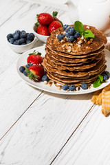 stack of homemade delicious pancakes for breakfast on white table, vertical top view