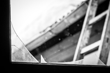 Fototapeta premium broken window in attic, showing ladder exit in the background