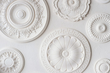 White discs of different shapes and sizes are placed on a white wall