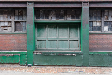 Large green loading dock door on a vintage red brick factory