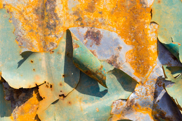 Old rusty metal background with peeling gray paint. Rusty flaky cracked metal surface. Abstract textures of the surface of the old metal