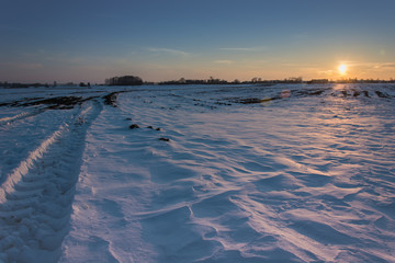 Sunny light on a large snowy field before sunset