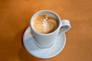 Cup of beautiful Latte art coffee on the wooden table in coffee shop, Top view of hot coffee cappucino cup.