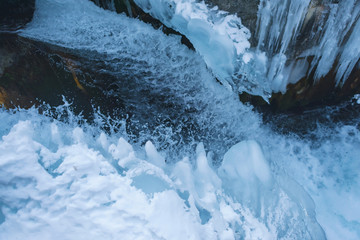Frozen water channel. Mountain river in winter. Icing on the bank of the stream. Bypass channel....